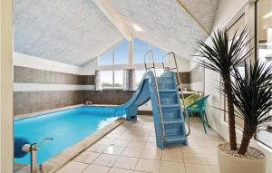 VejbyにあるNice Home In Vejby With Outdoor Swimming Poolのホテルの客室内にスライド付きの屋内スイミングプールがあります。