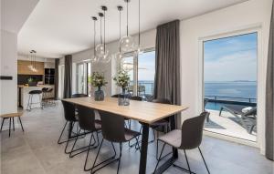 a dining room with a table and chairs and a large window at Beach Front Home In Prizna With House Sea View in Prizna