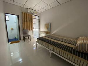a bedroom with a bed and a chair in it at Peaceful Townhouse near BKK in Ban Khlong Hua Sakae