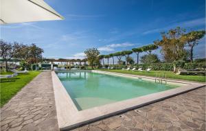 a swimming pool in a park with chairs and trees at Beautiful Home In Anguillara Sabazia With 11 Bedrooms, Private Swimming Pool And Outdoor Swimming Pool in Anguillara Sabazia