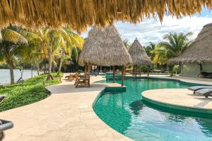 ein Resort mit einem Pool mit strohgedeckten Sonnenschirmen in der Unterkunft Villa Fiesta at Morningstar Breeze Gold Standard Certified in Hopkins