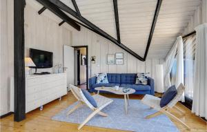 尼斯泰茲的住宿－3 Bedroom Lovely Home In Nysted，客厅配有蓝色的沙发和椅子