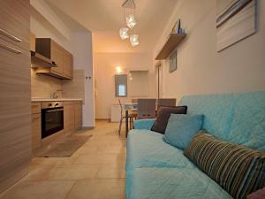 sala de estar con sofá azul y cocina en Roma 202 by Tempovacanza, en Laigueglia