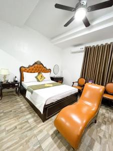 um quarto com uma cama e uma cadeira em Hoàng Gia Đông Anh Hotel em Dong Anh