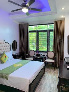 um quarto com uma cama e uma ventoinha de tecto em Hoàng Gia Đông Anh Hotel em Dong Anh