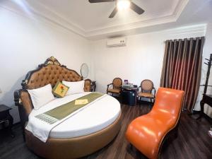 um quarto com uma cama grande e uma cadeira em Hoàng Gia Đông Anh Hotel em Dong Anh