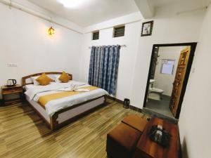 1 dormitorio con cama y espejo en Jain Homestay, en Darjeeling