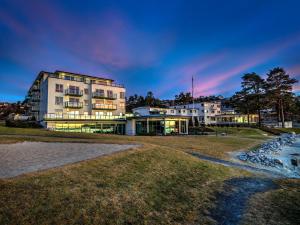 un edificio en la orilla de un cuerpo de agua en Strand Hotel Fevik - by Classic Norway Hotels en Fevik