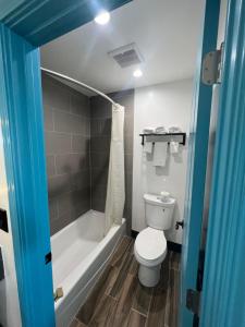 a bathroom with a toilet and a tub and a shower at Palm Inn Los Angeles NEW in Inglewood