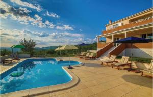 a swimming pool with chairs and umbrellas next to a building at Stunning Home In Radosic With Wifi, Outdoor Swimming Pool And Heated Swimming Pool in Radošić