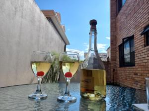 Una botella de vino y dos copas en una mesa. en Departamento excelente ubicación con parqueo, en Cuenca