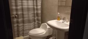 y baño con aseo y lavamanos. en Departamento excelente ubicación con parqueo, en Cuenca