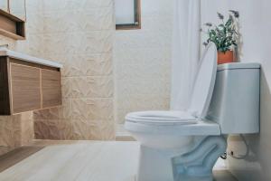 uma casa de banho com um WC branco e uma planta em Exclusive Beachfront House w/ Pool & Saltwater Tub em Catmon