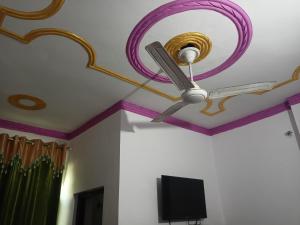 Cette chambre dispose d'un ventilateur de plafond et d'une télévision. dans l'établissement Tapasya Home Stay, à Dehradun