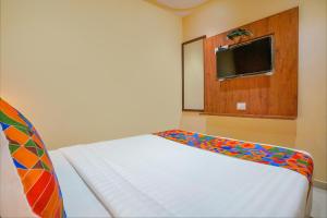 FabExpress Colaba Grand في مومباي: غرفة نوم صغيرة مع سرير أبيض وتلفزيون