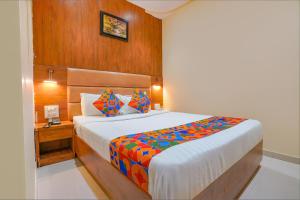 a bedroom with a bed and a wooden wall at FabExpress Colaba Grand in Mumbai