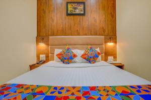 1 dormitorio con 1 cama con un edredón colorido en FabExpress Colaba Grand en Bombay