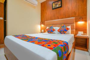 孟買的住宿－FabExpress Colaba Grand，一间卧室配有一张大床和色彩缤纷的毯子