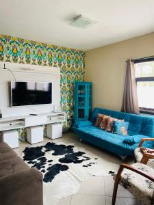 uma sala de estar com um sofá azul e uma televisão em Rio Grande Beach House em Rio Grande