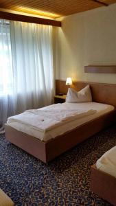 Un dormitorio con una cama grande y una ventana en Hotel Tannenhof, en Lauterbach