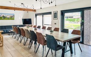 een eetkamer met een lange tafel en stoelen bij Cozy Home In Diksmuide With Outdoor Swimming Pool in Diksmuide