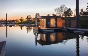 a house sitting on top of a body of water at Houseboat Waterlelie in Ohé en Laak