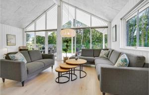 a living room with two couches and a table at Beautiful Home In Væggerløse With Sauna in Marielyst