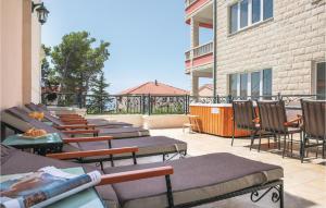 a row of chairs and tables on a patio at Cozy Home In Makarska With Jacuzzi in Makarska