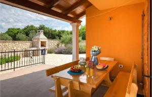 a table with a bowl of fruit on it on a patio at Awesome Home In Hr-52215 Vodnjan With House Sea View in Vodnjan