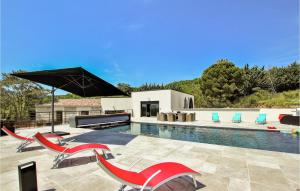 a swimming pool with red chairs and an umbrella at Gorgeous Home In Alissas With Kitchen in Alissas