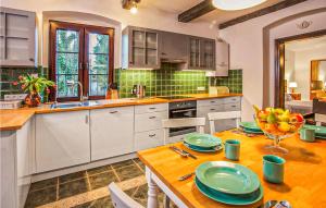 a kitchen with a wooden table with plates on it at Cozy Home In Sasino With Kitchen in Sasino