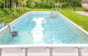 an empty pool with a slide in a backyard at Cozy Home In Sasino With Kitchen in Sasino