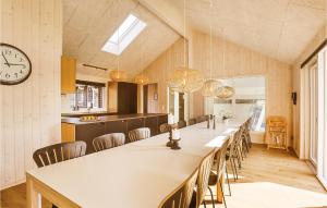 a large dining room with a long table and a clock at Cozy Home In Vejby With Indoor Swimming Pool in Vejby