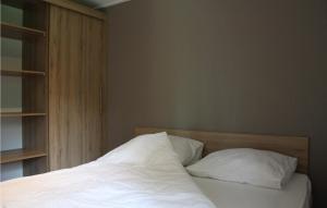 1 dormitorio con 1 cama con sábanas y almohadas blancas en Chalet 101 en Oosterwolde