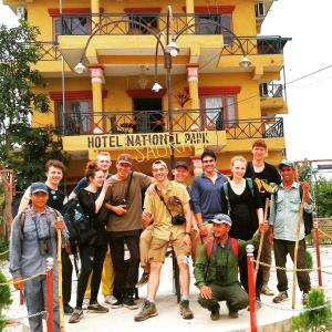 a group of people posing for a picture in front of a building at Hotel National Park Sauraha in Sauraha