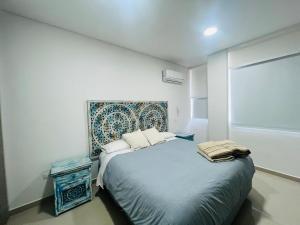 1 dormitorio con 1 cama con cabecero azul en Samaria Club de playa, Sector Pozos Colorados, en Santa Marta