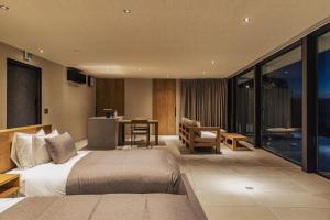 Habitación de hotel con cama, mesa y cocina en WEAZER 西伊豆, en Izu 51 fotos más