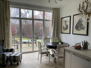 eine Küche mit einem Tisch und Stühlen sowie einem großen Fenster in der Unterkunft Haus Mathilda in Papstdorf