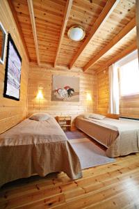 a bedroom with two beds in a wooden cabin at Villa Struka in Pyhtaa