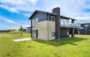a house with a balcony on a grass field at Amazing Home In Nimtofte With Wifi in Nimtofte