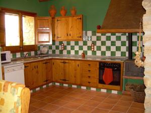 kuchnia z drewnianymi szafkami oraz zielonymi i białymi kafelkami w obiekcie Casa Rural el Castellet w mieście La Jana +9 zdjęć