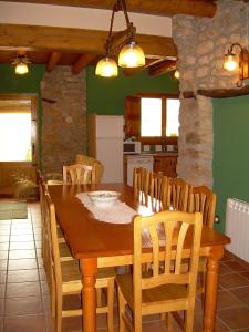 cocina y comedor con mesa de madera y sillas en Casa Rural el Castellet, en La Jana