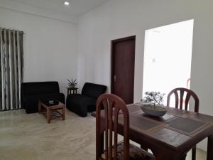 sala de estar con mesa de madera y sillas en Gloria Inn en Negombo