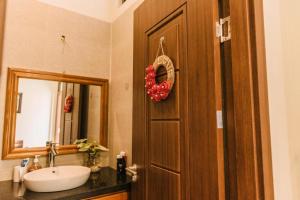 ein Bad mit einem Waschbecken und eine Tür mit einem Spiegel in der Unterkunft Chi Homestay #4 in Hue