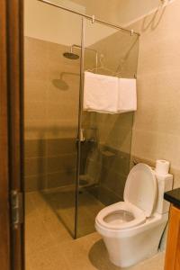 a bathroom with a toilet and a glass shower stall at Chi Homestay #4 in Hue