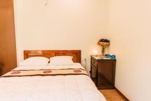 a bedroom with a bed with a wooden headboard and a table at Chi Homestay #4 in Hue