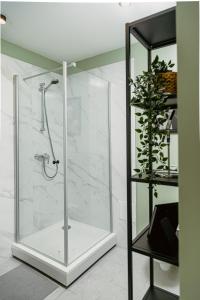 a shower with a glass door in a bathroom at Beautiful Studio in Downtown Riga - Great Location in Rīga