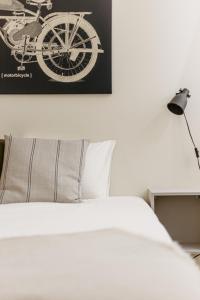 a bed with a black and white picture of a bike on the wall at Beautiful Studio in Downtown Riga - Great Location in Rīga