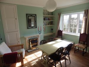 a living room with a table and a fireplace at Crow Corner in Yoxford