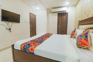 a bedroom with a bed and a tv on the wall at FabHotel The Villa in Kānpur